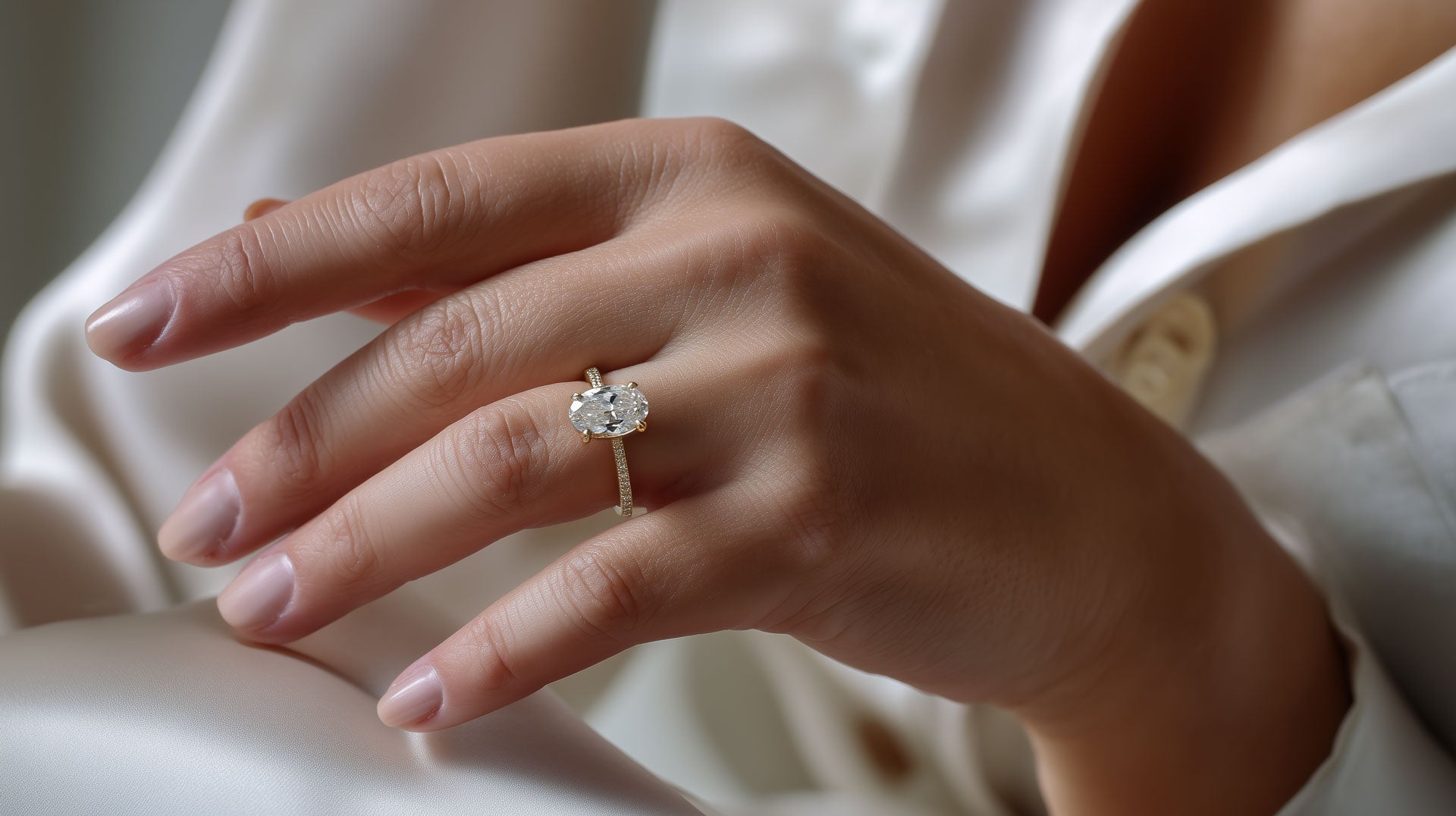 Oval Diamond solitaire engagement ring on woman's hand